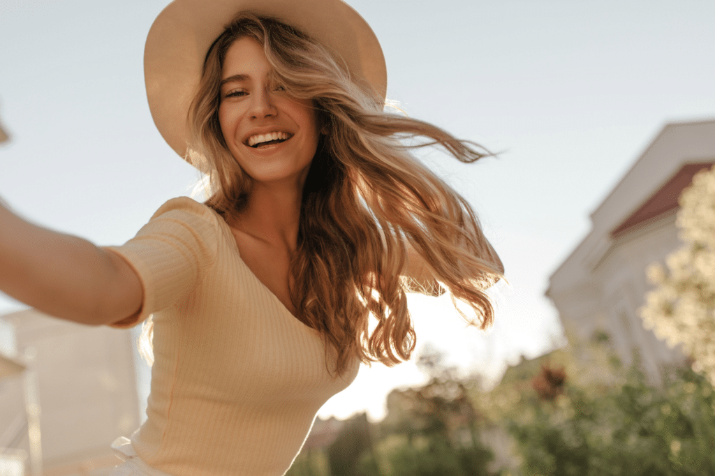 Smiling young woman in a sun hat taking a selfie