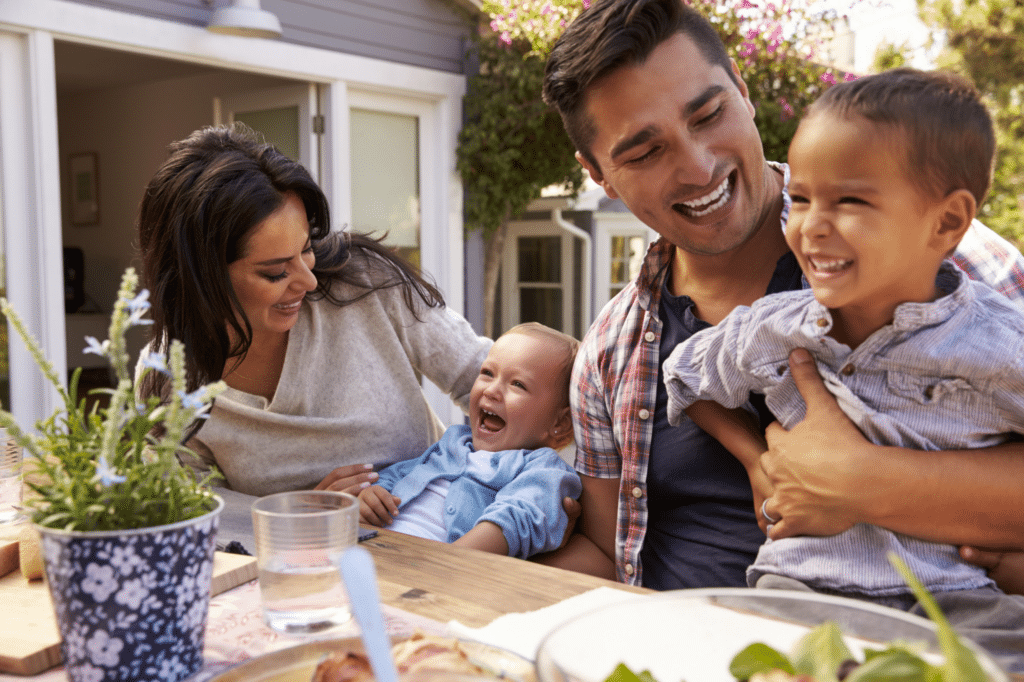 Family laughing around an outdoor table