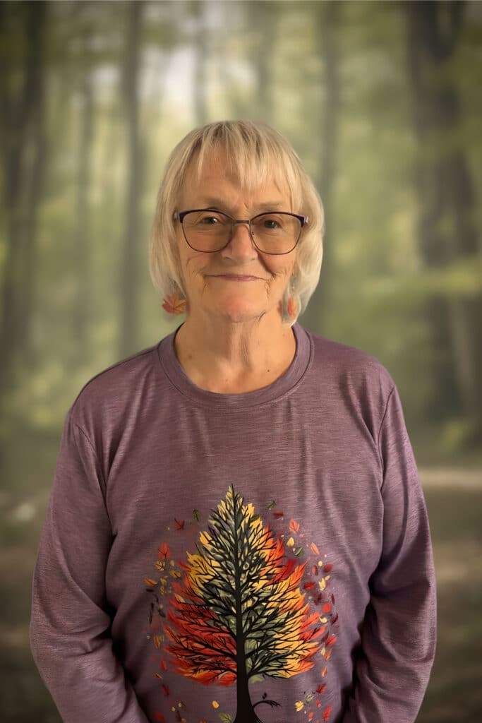 Jan, front desk, in a tree-print sweater