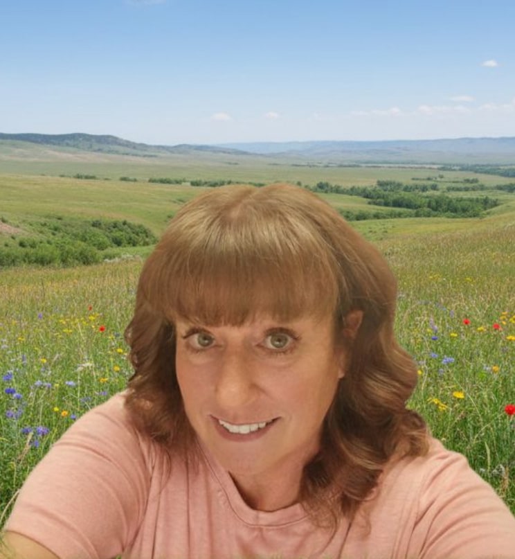 Lisa, EDDA, smiling in a field of wildflowers